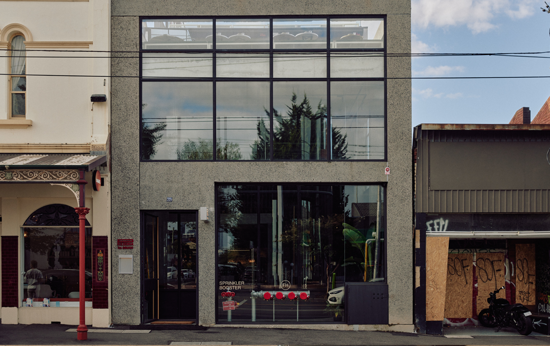 A simple concrete shopfront shot during the day from the street.